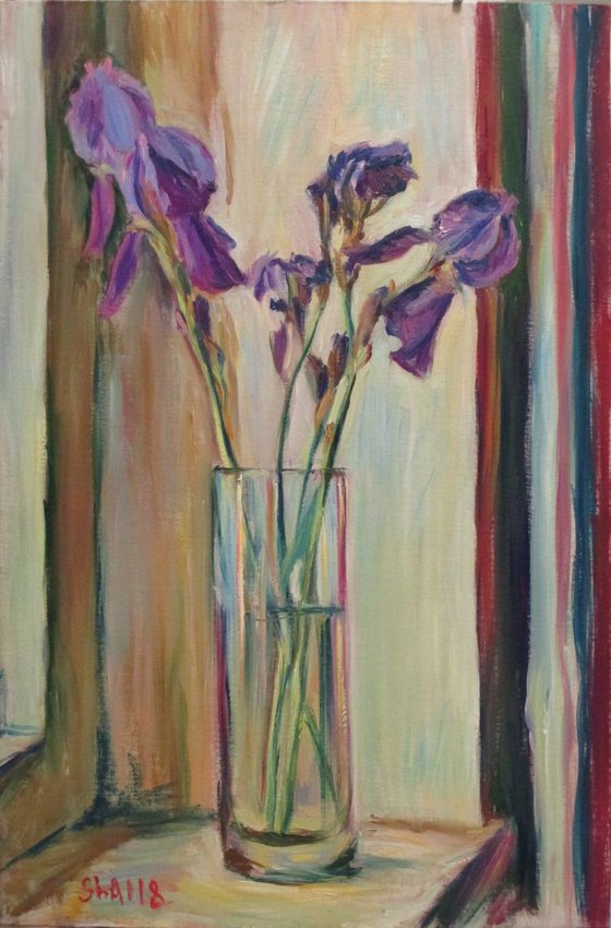 Purple irises in a long vase