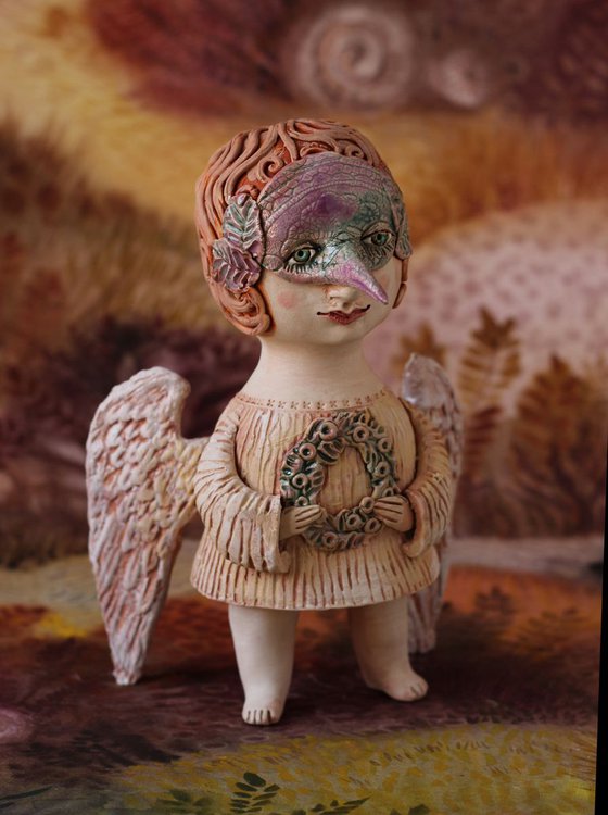 Angel holding a mask. Ceramic OOAK sculpture.