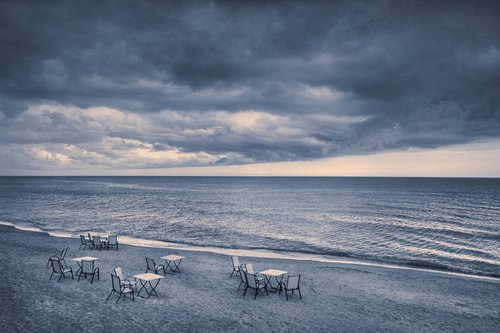 There are many empty seats in the coastal cafe before the storm. by Valerix