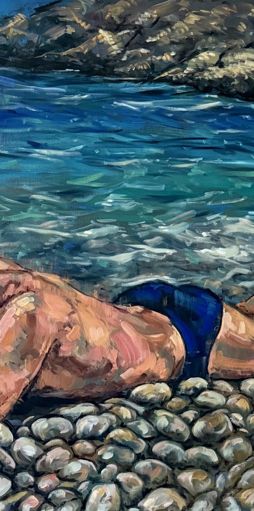 Man lying down at the beach by Emmanouil Nanouris