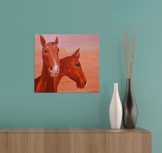 Chestnut horses at soft pink orange sunset