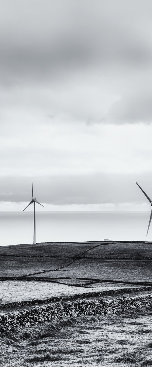 Four wind blades overlooking the ocean by Karim Carella