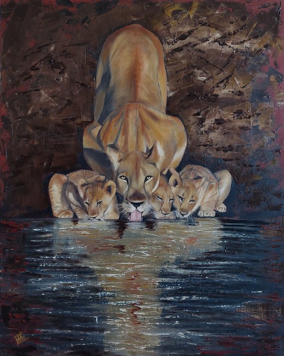 Lioness with cubs by the water