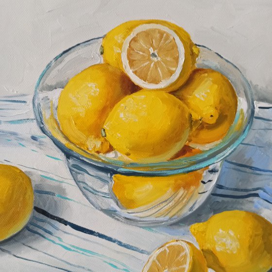 Lemons in glass bowl on stripen tablecloth