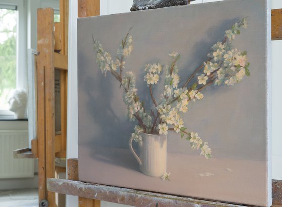 Flowering branches in a white mug