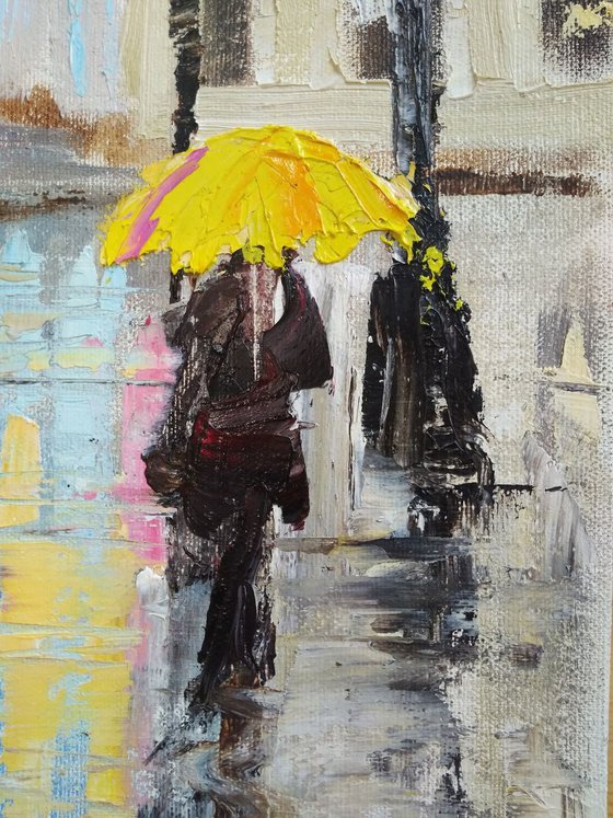 Rainy evening in the City and woman with yellow umbrella