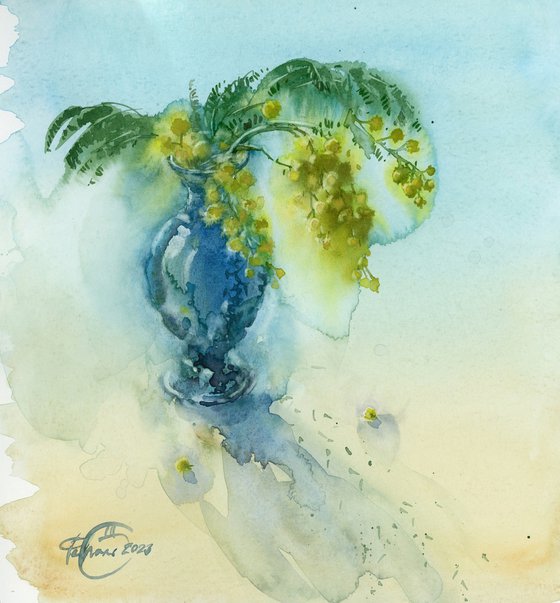 A sprig of mimosa in a small blue vase. Still life. Spring.