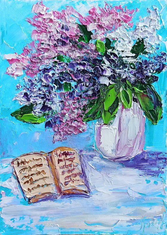 Lilac flowers and a book still life