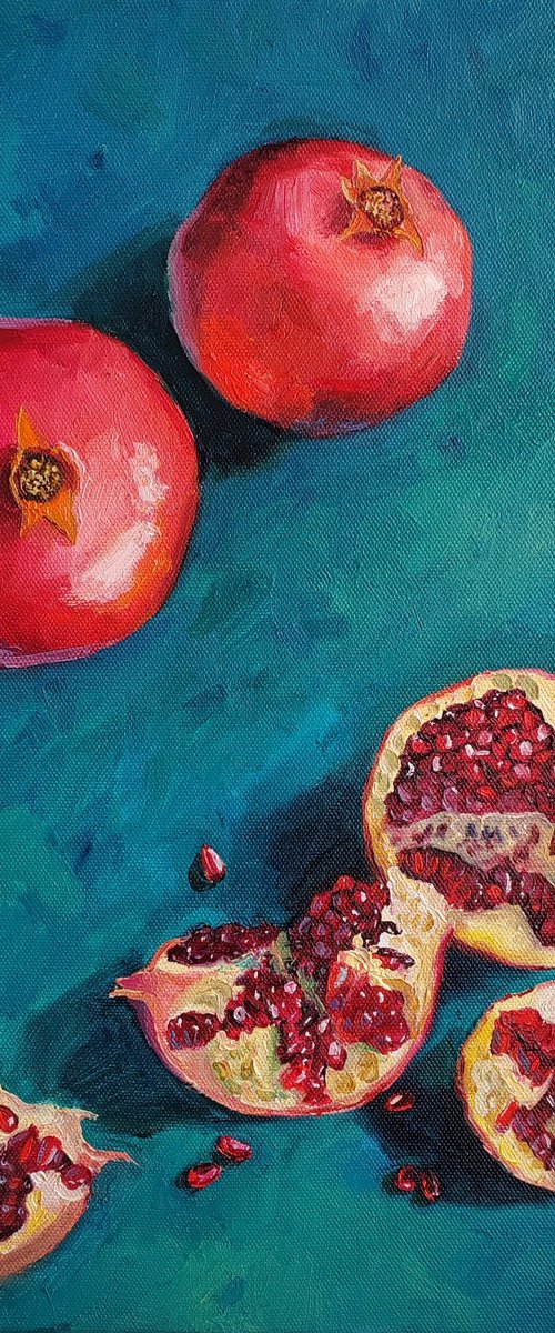 Pomegranate slices and seeds on deep blue bakground by Leyla Demir