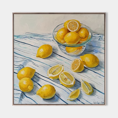 Lemons in glass bowl on stripen tablecloth by Leyla Demir