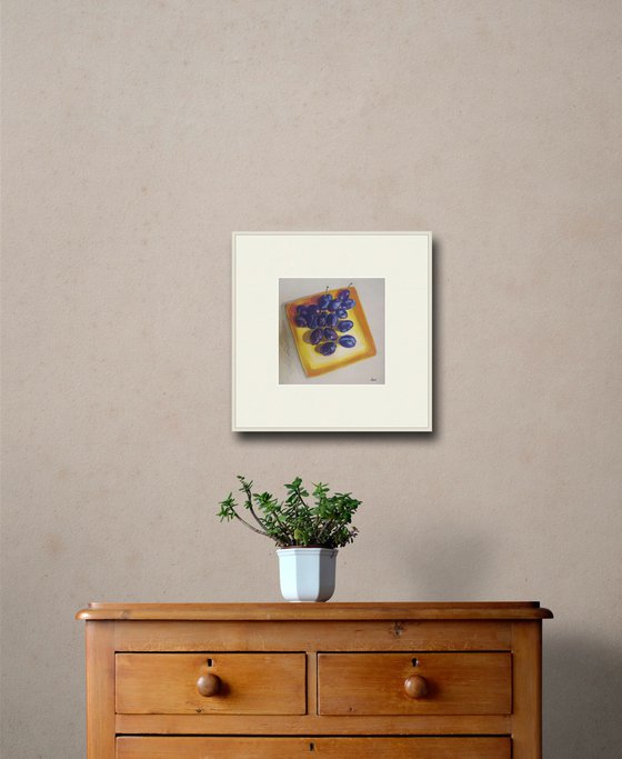 Blue plums on a yellow dish