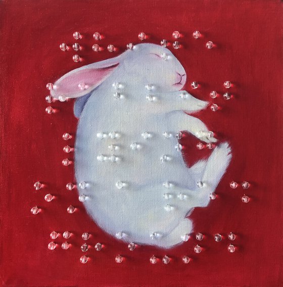 White rabbit lying on a red ground