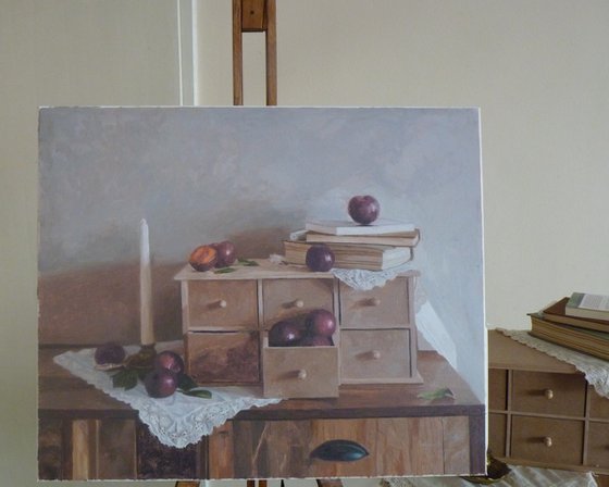 Plums, candle and books