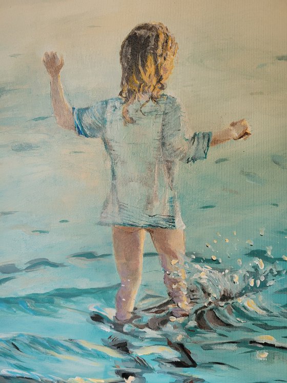 Childhood. Little girl walking into the sea.