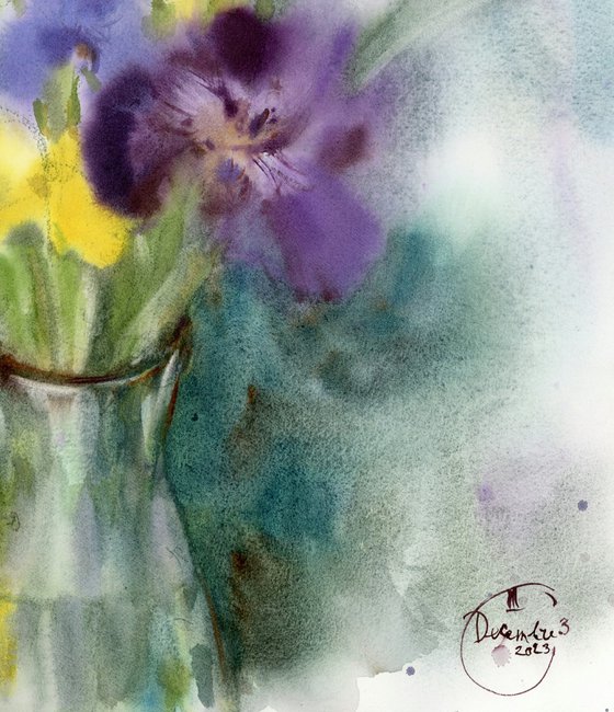 Bouquet of purple and yellow irises in a glass vase.