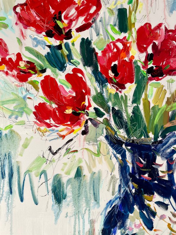 Red tulips in a blue vase.