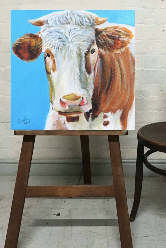 Cow painting a portrait in blue