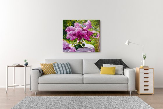 Lilac bouquet in a glass vase in the garden still life