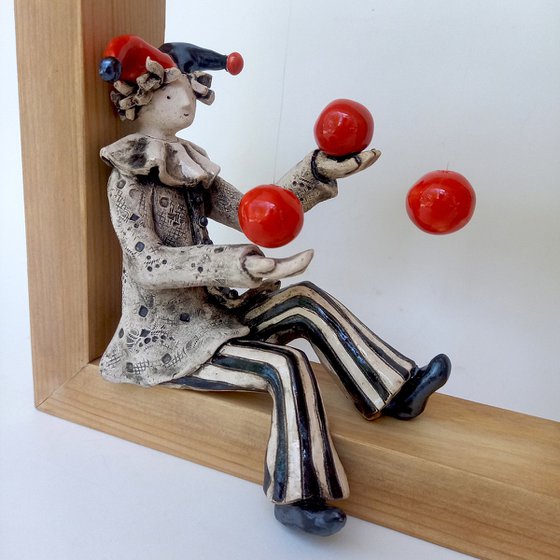 A clown playing with balls