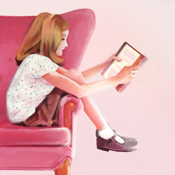 Girl in pink chair with book