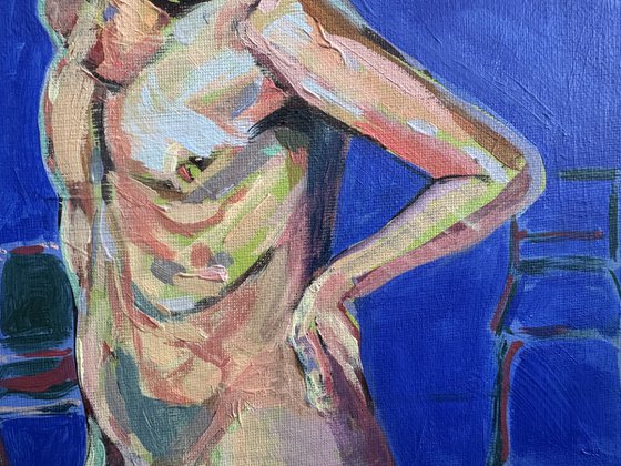 Young nude man in blue room