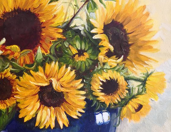 Sunflowers bouquet in a blue glass vase still life