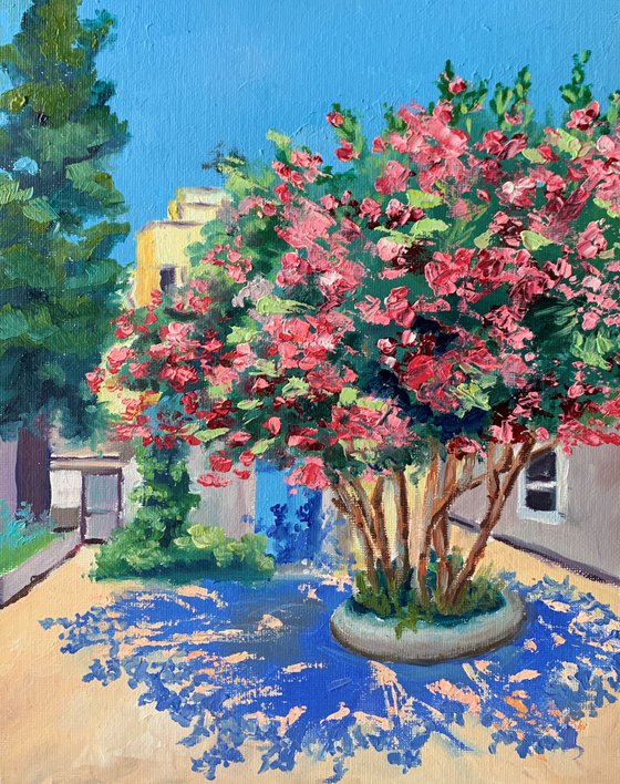 Summer sityscape, pink blossom tree.