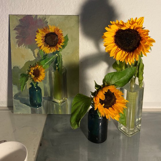 Sunflowers with a blue glass