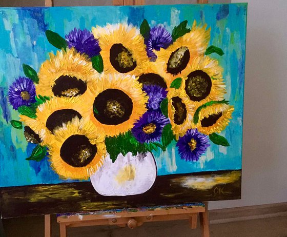 Sunflowers and asters in a white vase.