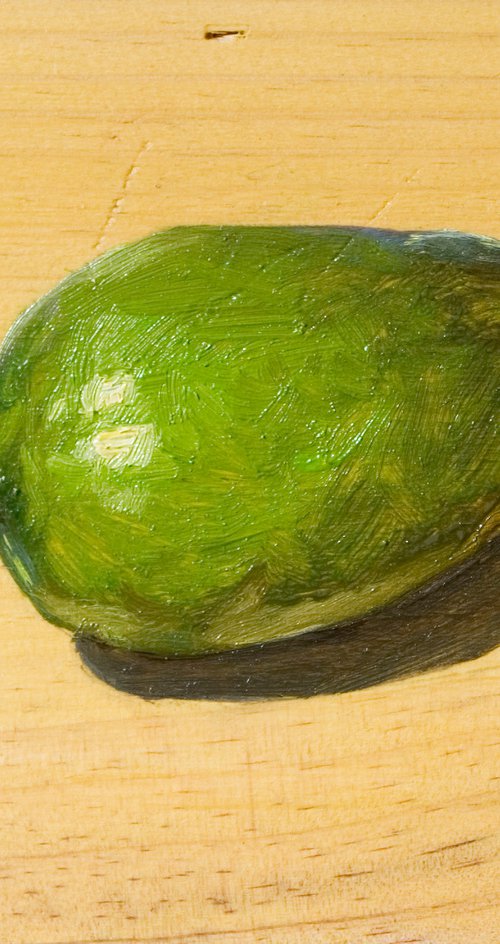 green avocado on a wood board for food lovers by Olivier Payeur