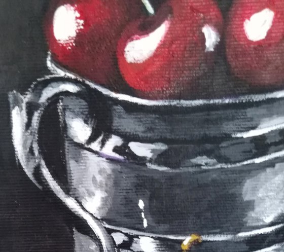 Red cherries in a metal cup