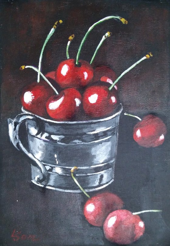 Red cherries in a metal cup