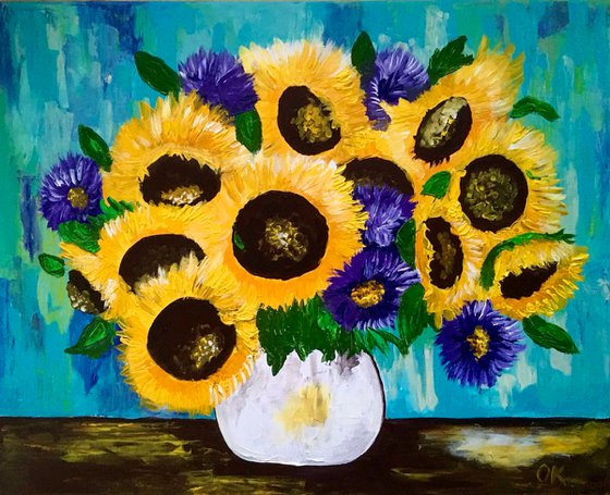 Sunflowers and asters in a white vase.
