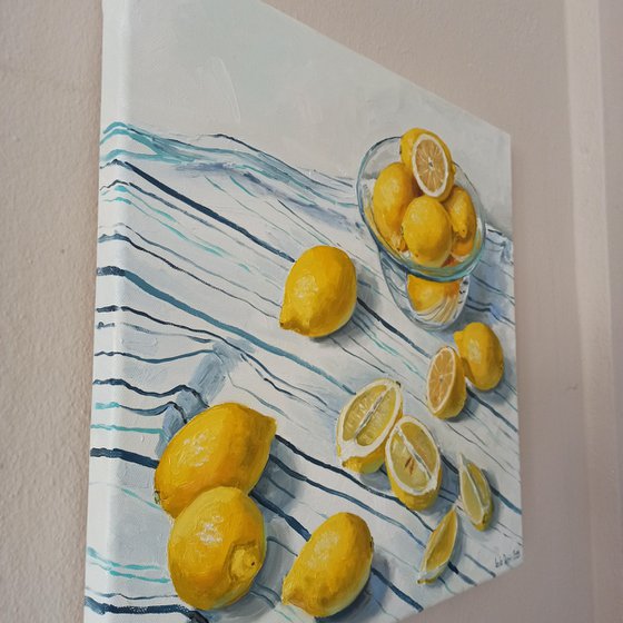 Lemons in glass bowl on stripen tablecloth