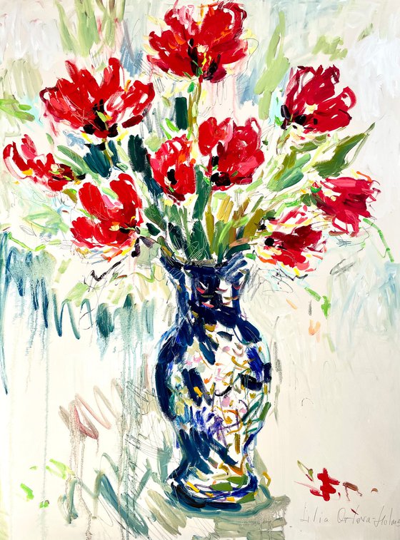Red tulips in a blue vase.
