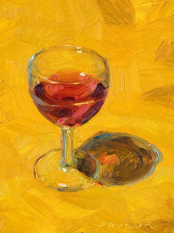 glass of red wine on yellow