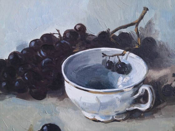 Black grapes and a porcelain cup still life