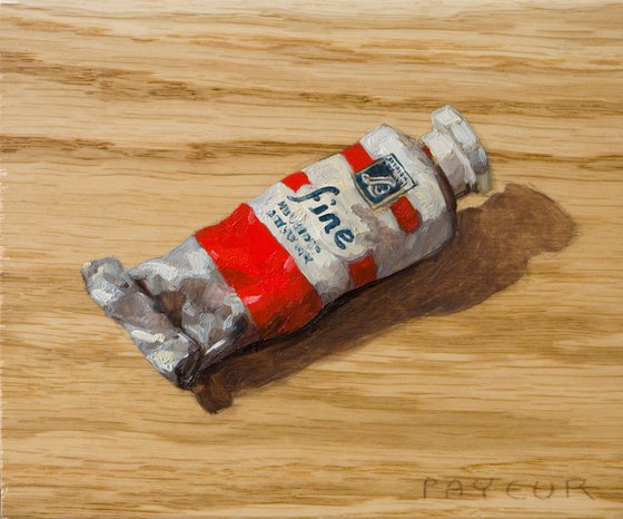 modern still life of a red color painting tube on a plank board