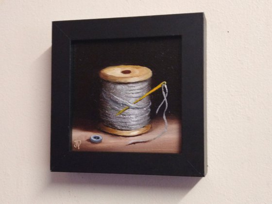 Little silver thread with golden needle still life