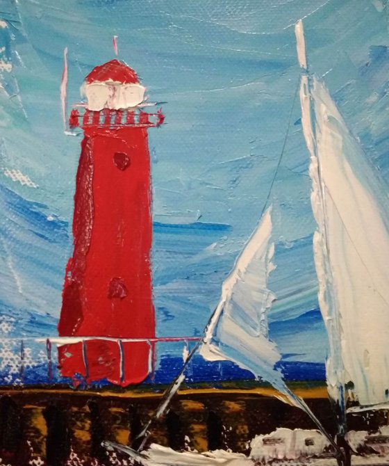 Sailing yacht and the red lighthouse