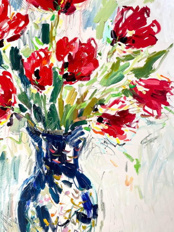 Red tulips in a blue vase.