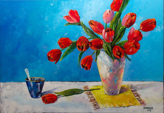 Tulips on a yellow napkin and blue cup of tea