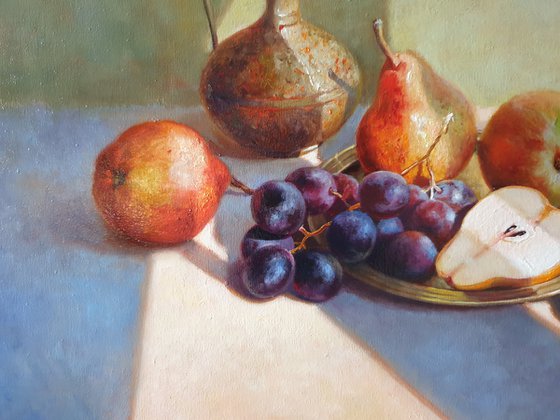 Fruits and a small brass jug.