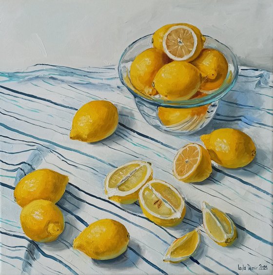 Lemons in glass bowl on stripen tablecloth