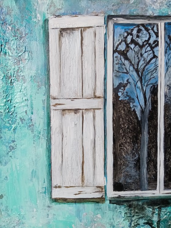 A window in an old turquoise wall