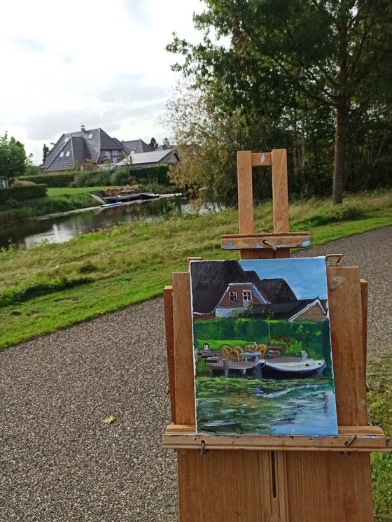 Small boat by house at canal