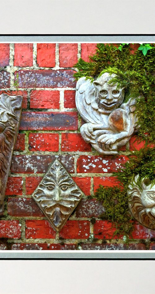 Faces on a wall sculpture by Robin Clarke