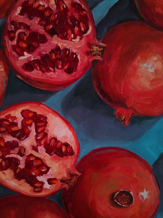 Ripe red pomegranates on turquoise - blue background still life