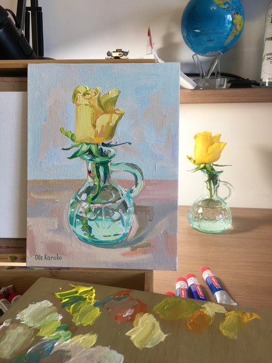 Yellow rose in a glass vase on a light background.