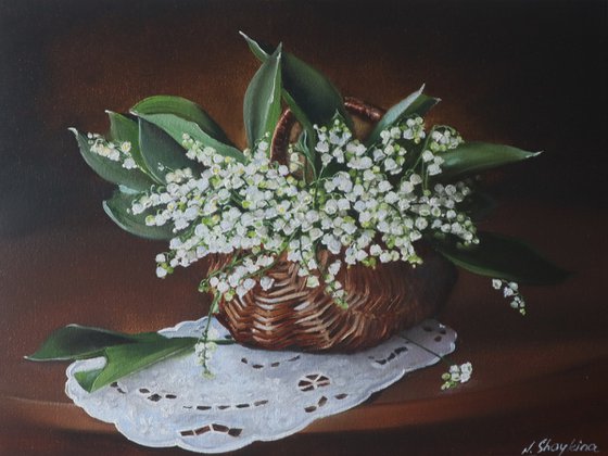 Lilies of the valley in rustic basket